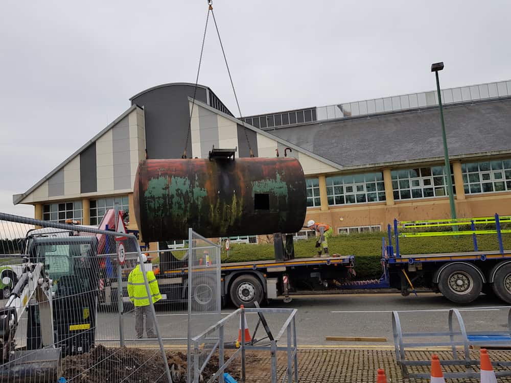 The first of the old oil tanks is removed from site ready to be loaded for transportation