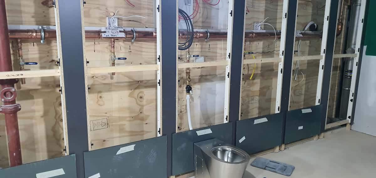 Plumbing hidden behind panelling at Im a Celebrity Jungle Challenge with plumbing by Kimpton