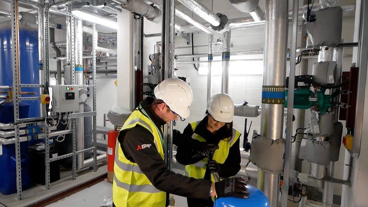 Phil and Meg working together on a boiler room maintenance project in Liverpool