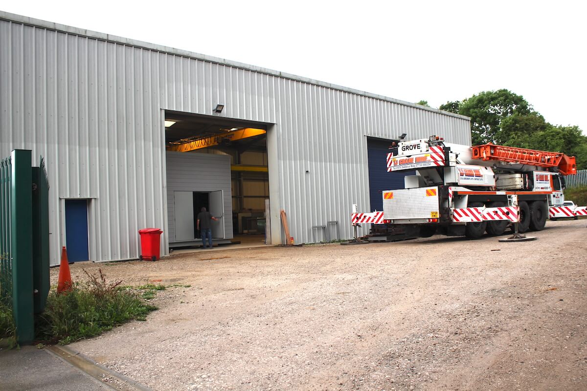 The crane has arrived and the acoustic plant room is being pulled out for loading